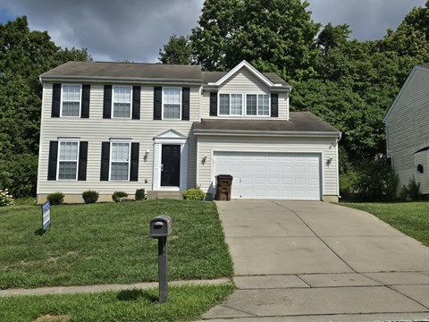 A two-story house with a garage and a mailbox in front.